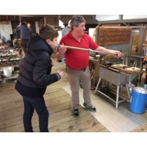 Paul souffle pour fabriquer un vase.